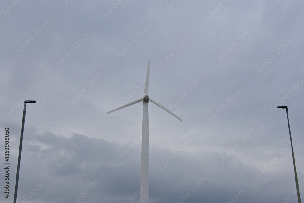 a wind turbine with three blades against a cloudy sky. Wind turbines generate renewable energy by converting wind power into electricity, essential for sustainable energy solutions. a wind turbine with three blades against a cloudy sky. Wind turbines generate renewable energy by converting wind power into electricity, essential for sustainable energy solutions.