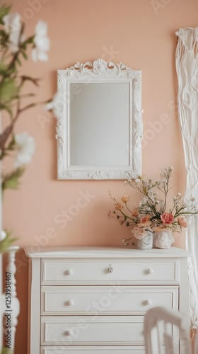 A delicate peach-colored wall with floral decor and a white frame placed above the dresser.