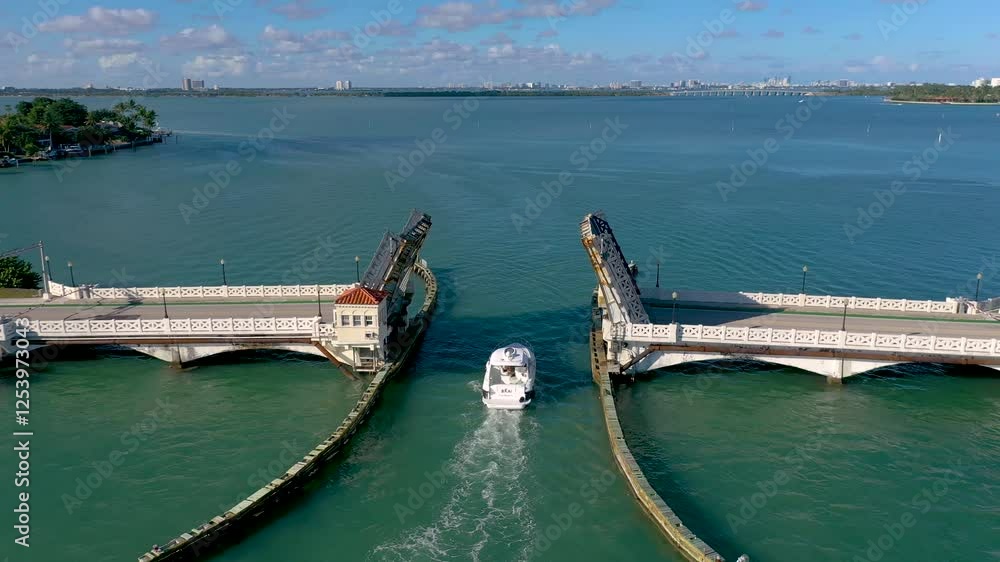 MIAMI, UNITED STATES - FEBRUARY 8, 2025: Boat passing through open drawbridge in scenic waterway surrounded by vibrant city skyline MIAMI, UNITED STATES - FEBRUARY 8, 2025: Boat passing through open drawbridge in scenic waterway surrounded by vibrant city skyline