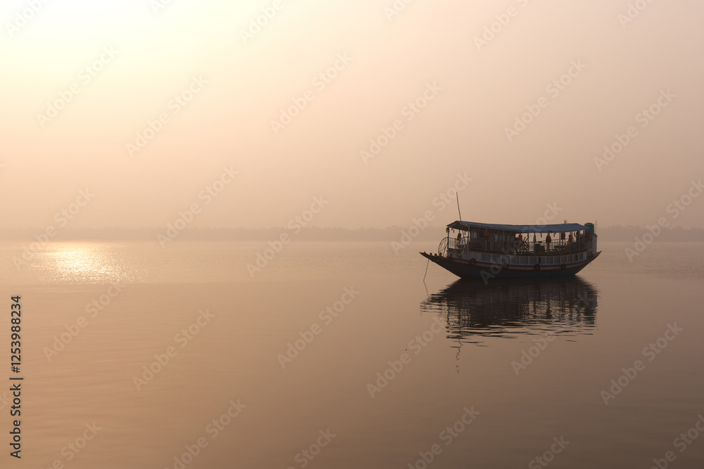 Obraz premium A boat sailing at Sundarban tiger reserve during sunrise in a foggy morning, India