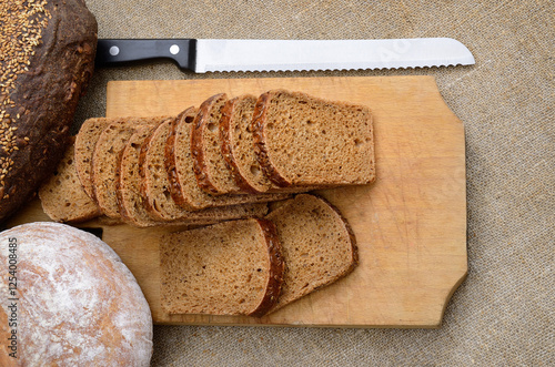 Fresh bread loaf with a knife on a cutting board
