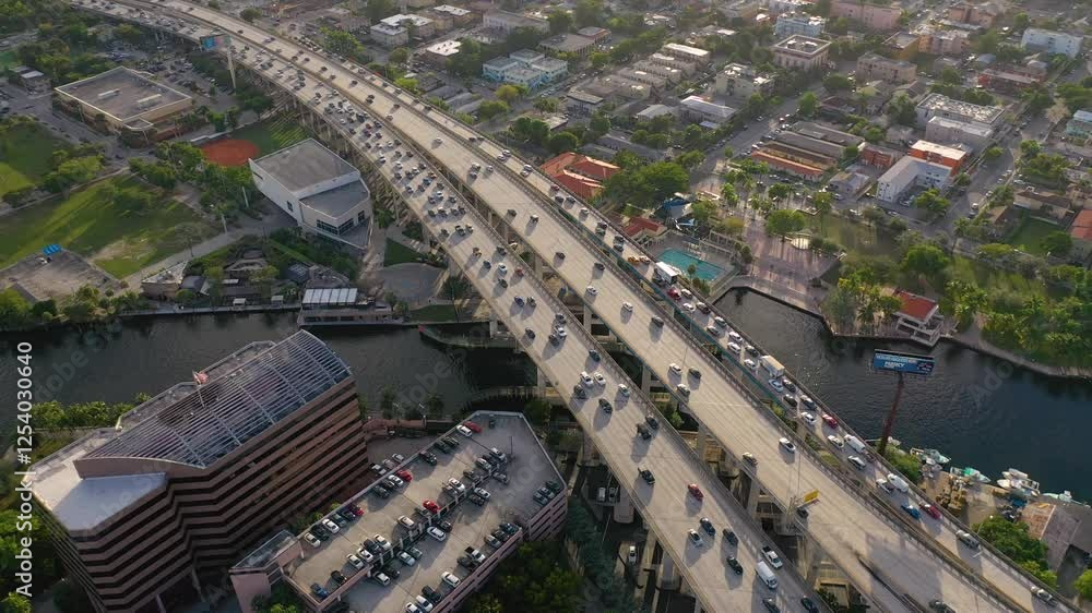 MIAMI, UNITED STATES - FEBRUARY 8, 2025: Busy highway traffic above waterways and city buildings during afternoon rush hour MIAMI, UNITED STATES - FEBRUARY 8, 2025: Busy highway traffic above waterways and city buildings during afternoon rush hour