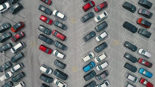 Aerial view of a large parking lot with rows of colorful parked cars. Perfect for automotive or logistics themes.