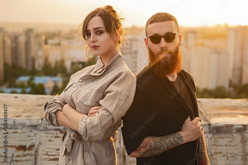 A fashionable couple stands confidently on a rooftop at sunset, exuding style and charisma, with an urban cityscape in the background. A fashionable couple stands confidently on a rooftop at sunset, exuding style and charisma, with an urban cityscape in the background.