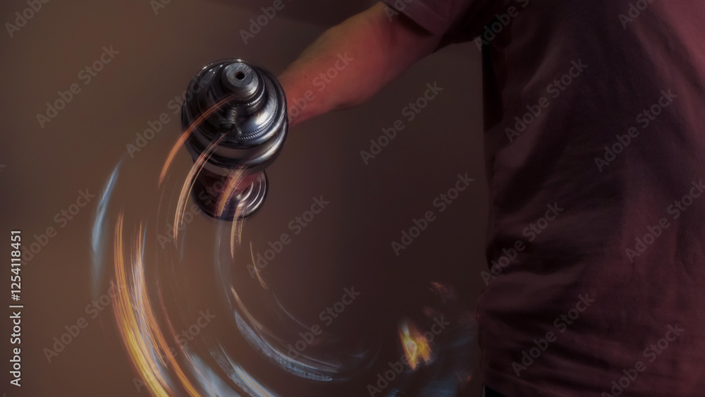 Athlete lifting dumbbell with motion blur effect in warm toned room
