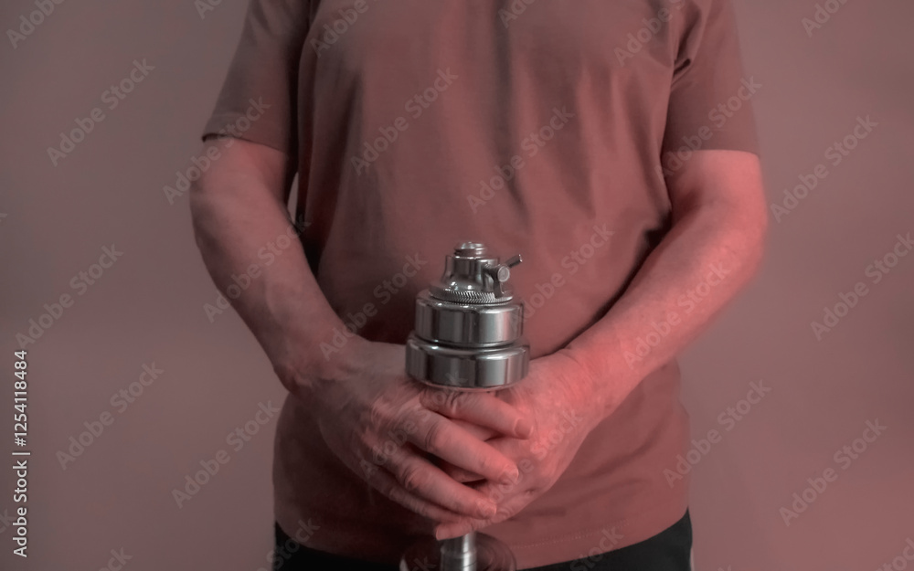 Senior man holding adjustable dumbbell horizontally, fitness and health in old age