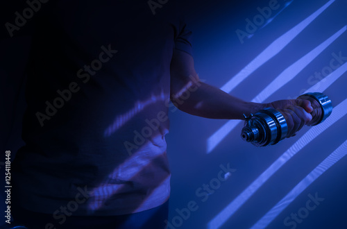 Obraz na płótnie Athlete lifting dumbbell showing muscle tension in dramatic lighting w salonie