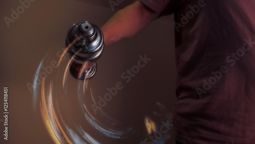 Obraz na płótnie Athlete lifting dumbbell with motion blur effect in warm toned room w salonie