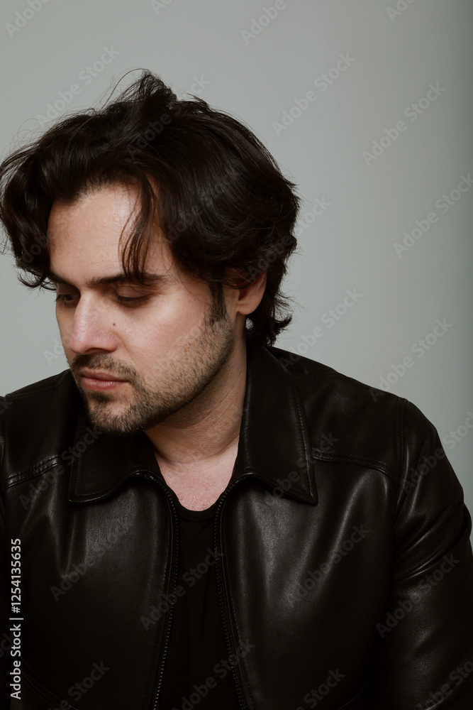 Obraz premium Portrait of bearded handsome man wearing black jacket. Vertical.