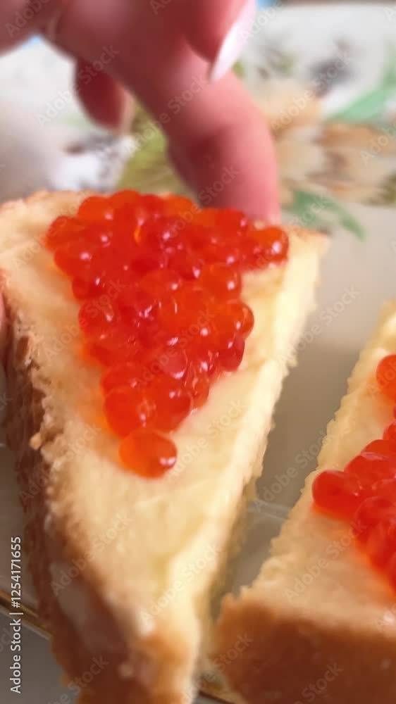 Putting red caviar on bread and butter, close-up of caviar sandwich. Salmon salted orange roe. Raw seafood. Luxury gourmet food. Delicious and tasty fish products. Russian cuisine. High quality 4k Putting red caviar on bread and butter, close-up of caviar sandwich. Salmon salted orange roe. Raw seafood. Luxury gourmet food. Delicious and tasty fish products. Russian cuisine. High quality 4k