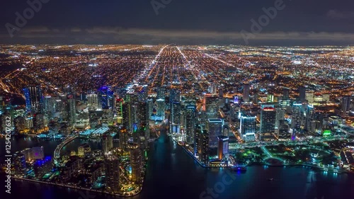 MIAMI, UNITED STATES - FEBRUARY 8, 2025: Aerial view of Miami skyline glowing at night with bright city lights over the water