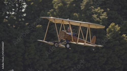 Vintage Biplane on a Field with Spectators in Period Attire