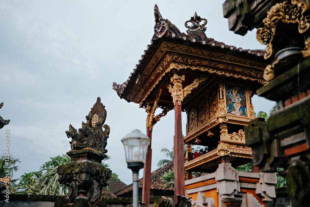 Naklejka premium This image captures a beautifully crafted Balinese temple structure, intricately decorated with gold accents and traditional carvings.