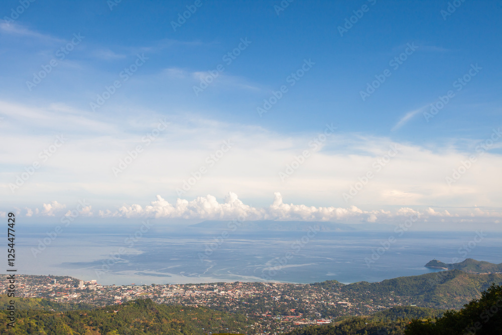 Fototapeta premium A beautiful view of Dili, the capital of East Timor, seen from a hill on the outskirts of the city. In the distance, the Cristo Rei statue, the icon of Dili, is visible.