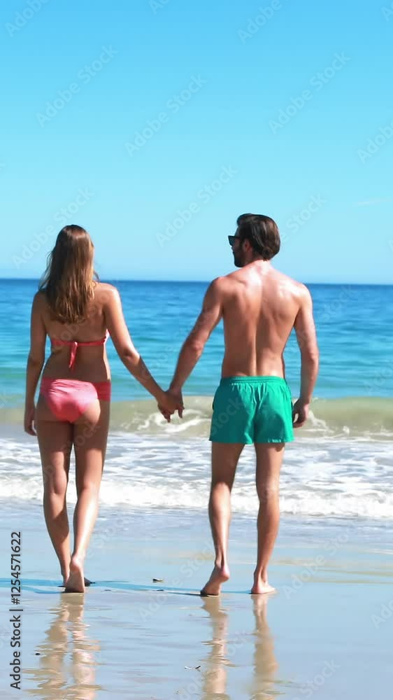 Rear view of couple walking on beach Rear view of couple walking on beach