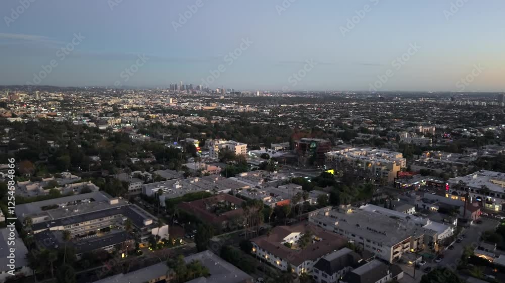 West Hollywood, California at dusk with a view of the Los Angeles city skyline on the horizon - aerial flyover West Hollywood, California at dusk with a view of the Los Angeles city skyline on the horizon - aerial flyover