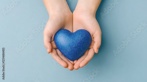 Hands Holding Blue Heart for Health and Happiness: A Symbol of Hope and Kindness on World Heart Day and Valentine's Day for Family Insurance and Health Care Wellness Donations