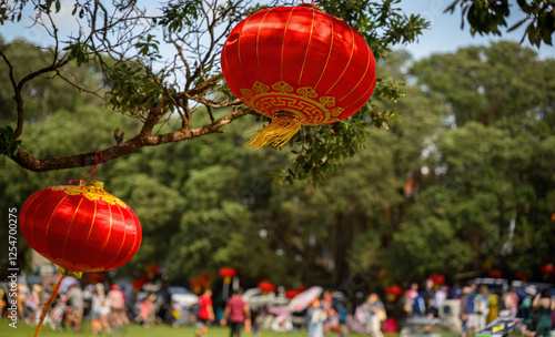 Obraz na płótnie Red lanterns hanging under the Pohutukawa trees. Big crowd of people celebrating Chinese New Year. Auckland. w salonie