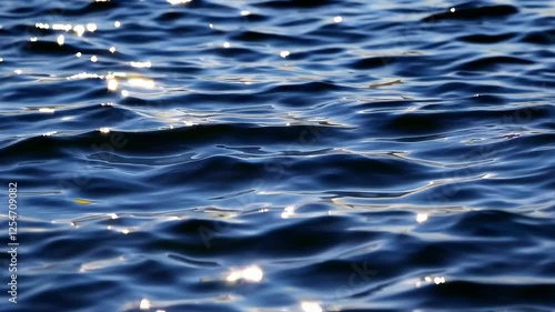 Calm ocean waves with sunlight reflections, serene and tranquil water scene. Nature and relaxation concept