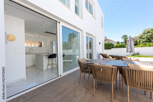 an image from a luxury garden terrace looking into an open marble kitchen in mediterranean villa real estate 