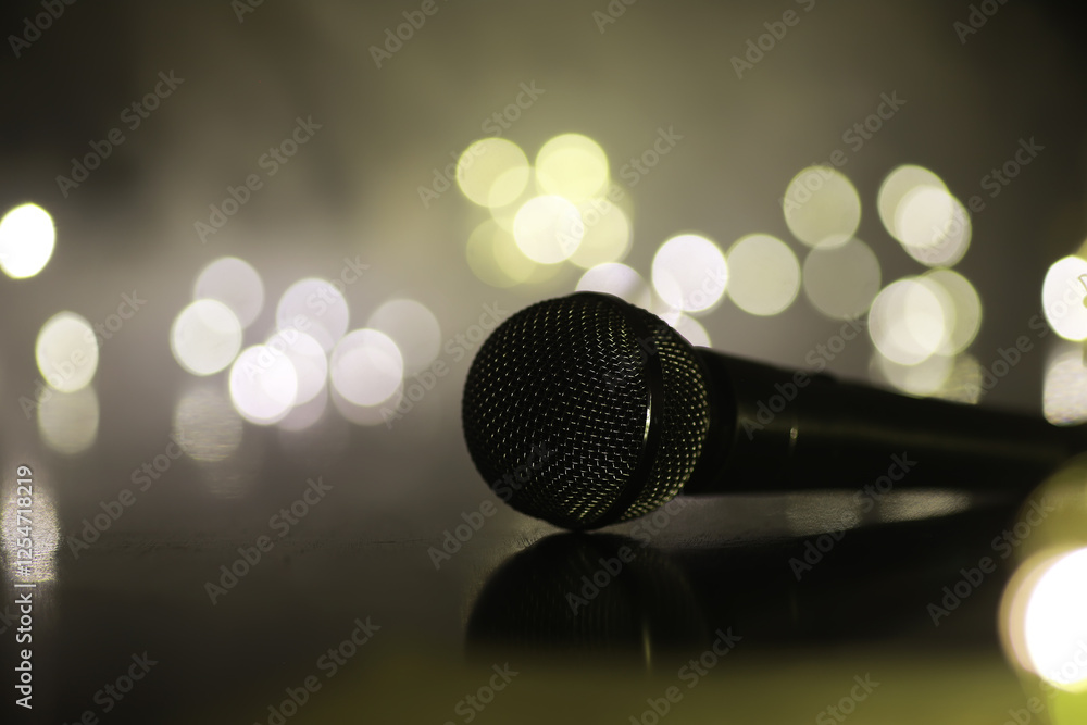 Obraz premium Close-Up of Microphone with Bokeh Lights in Background for Music, Performance, and Karaoke Themes