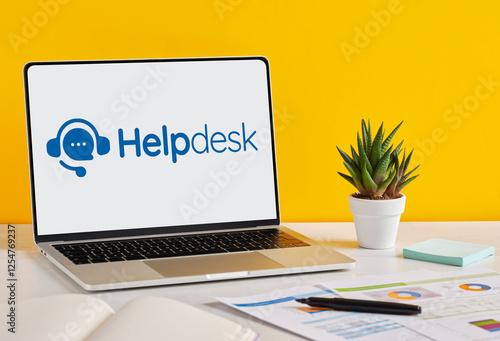 Tableau sur toile Laptop displaying helpdesk software on a desk with documents and plant