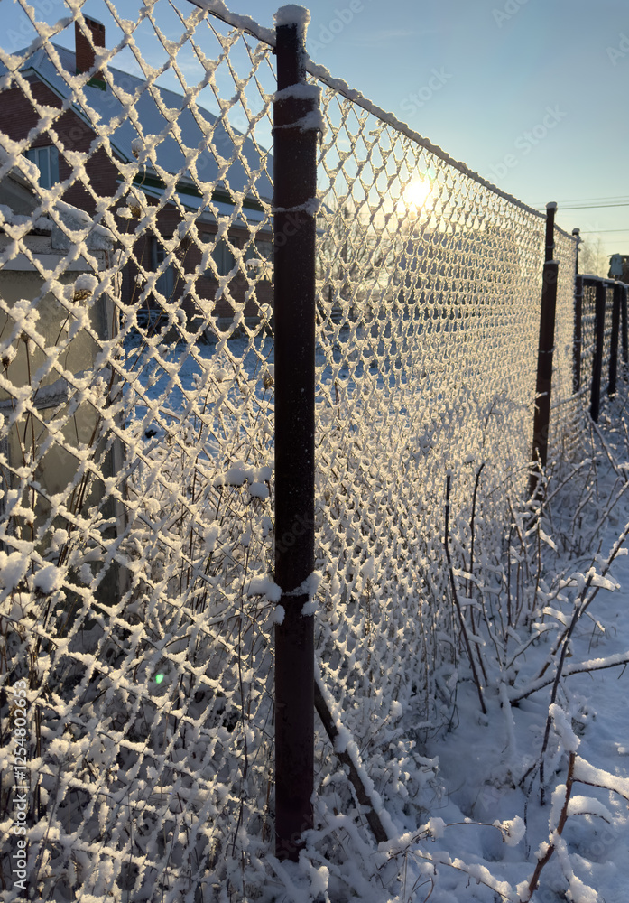 A fence covered in snow and a chain link fence A fence covered in snow and a chain link fence