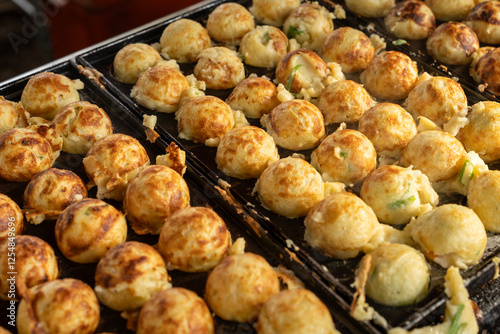 Cooking Delicious Takoyaki on a Grill with Wooden Sticks photo