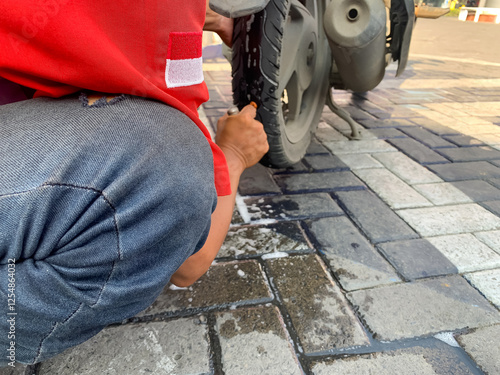 a man who was repairing a punctured motorbike tire