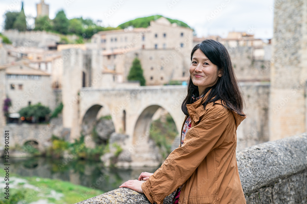 Φωτογραφία A woman smiles while exploring Besalú, a charming medieval town near Barcelona, Spain