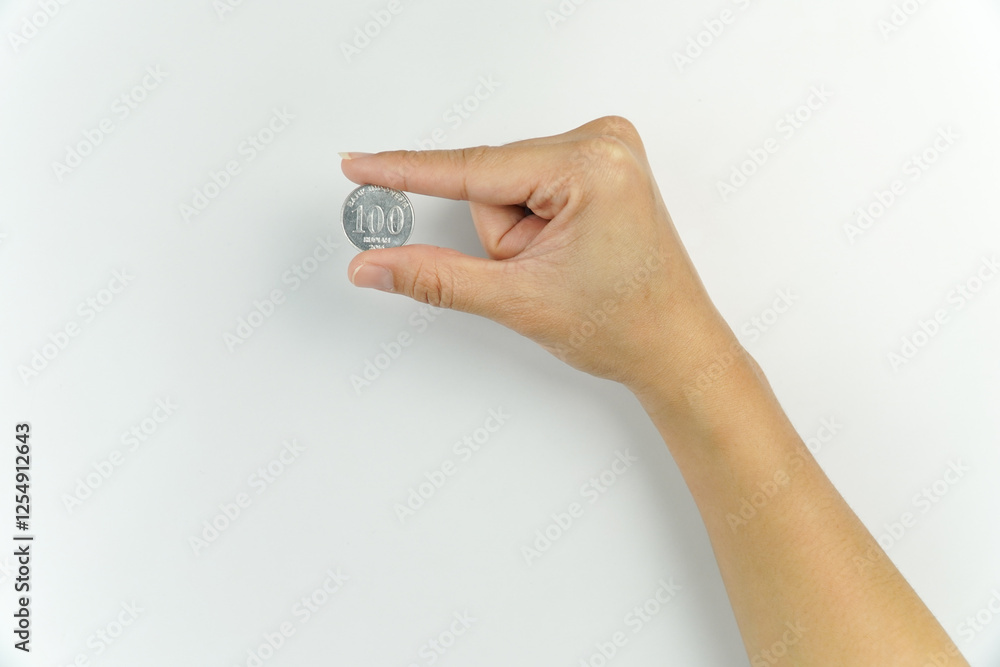 Hand Holding a 100 Rupiah Coin on White Background Hand Holding a 100 Rupiah Coin on White Background