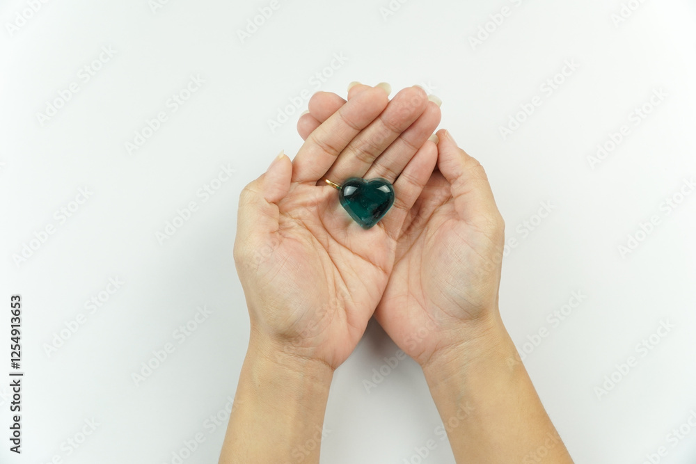 Hands Holding Green Heart-Shaped Gemstone Hands Holding Green Heart-Shaped Gemstone