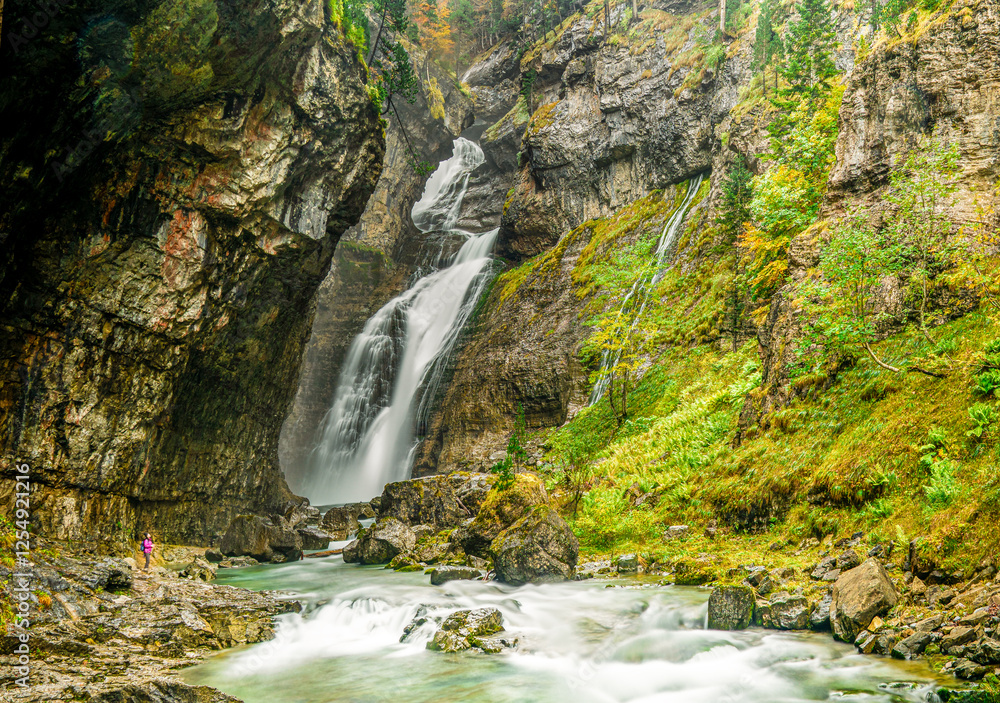 Φωτογραφία The magnificent Cascada del Estrecho in Ordesa National Park, Spain, showcases cascading waterfalls surrounded by mossy rocks, lush greenery, and rugged cliffs, epitomizing nature's raw beauty
