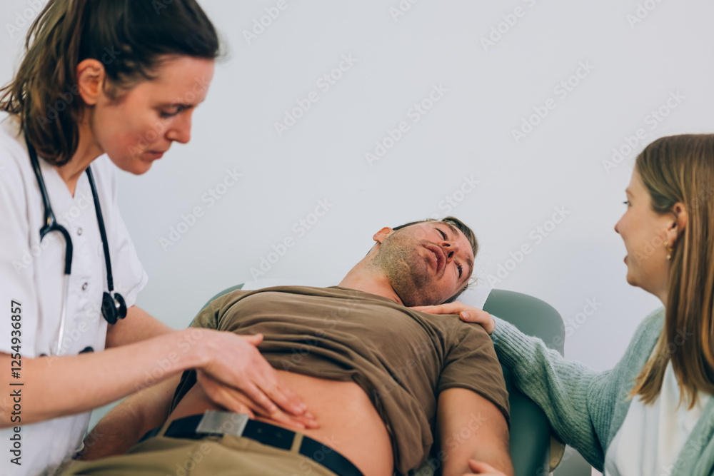 Obraz premium Doctor examining patient with stomach pain in medical office