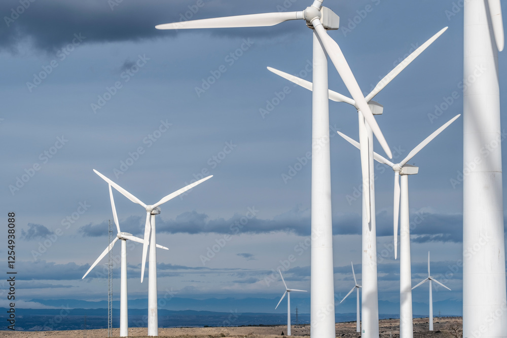 Close-up view of towering wind turbines against a bright blue sky in La Muela, Zaragoza, Spain, symbolizing clean energy and sustainable environmental solutions. Close-up view of towering wind turbines against a bright blue sky in La Muela, Zaragoza, Spain, symbolizing clean energy and sustainable environmental solutions.