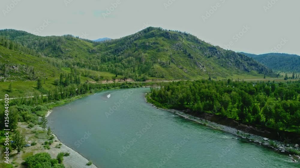 Aerial view from above over a mountain river and a green dense forest. Aerial view from above over a mountain river and a green dense forest.