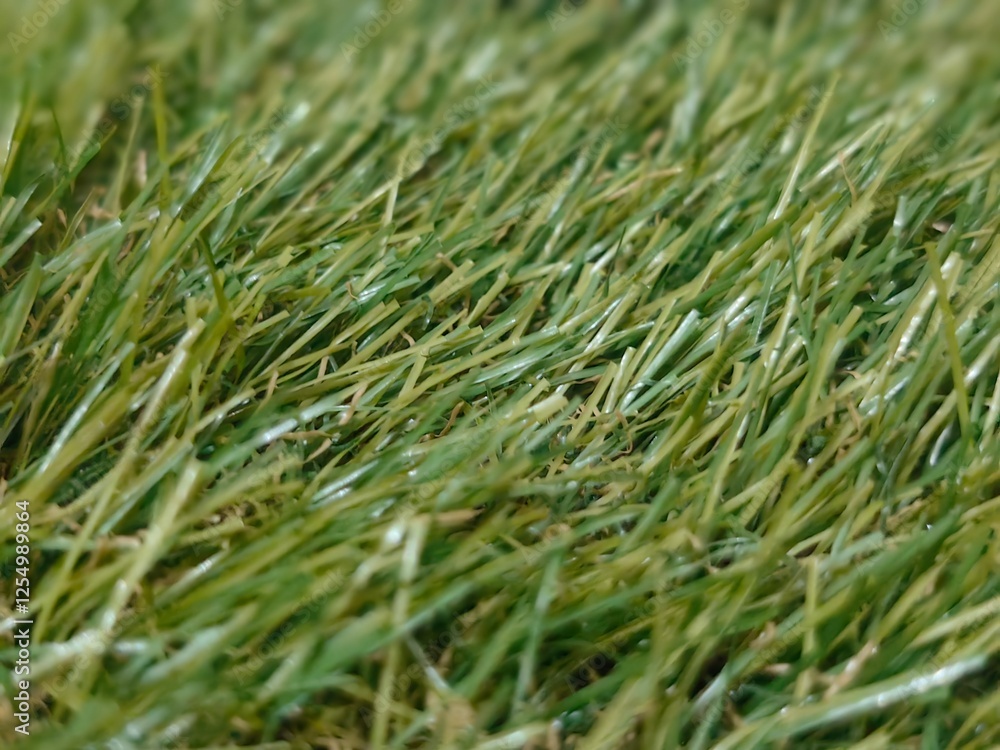 Close-up of artificial grass with realistic green texture, perfect for backgrounds, sports fields, or landscaping projects Close-up of artificial grass with realistic green texture, perfect for backgrounds, sports fields, or landscaping projects