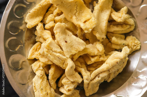 Selective Focus on Subject, Background Blur. danthal, Papdi, Are Deep Fried Snack Made From Chickpea Flour. Street food in an Indian Pouch, Bhavnagri Gathiya with Black Pepper, and Namkeen. photo