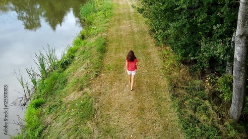 Young woman walks through a pine forest, restoring health and psyche in nature - Forest baths - Active lifestyle