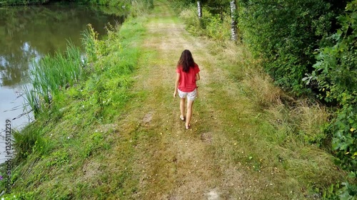 Young woman walks through a pine forest, restoring health and psyche in nature - Forest baths - Active lifestyle