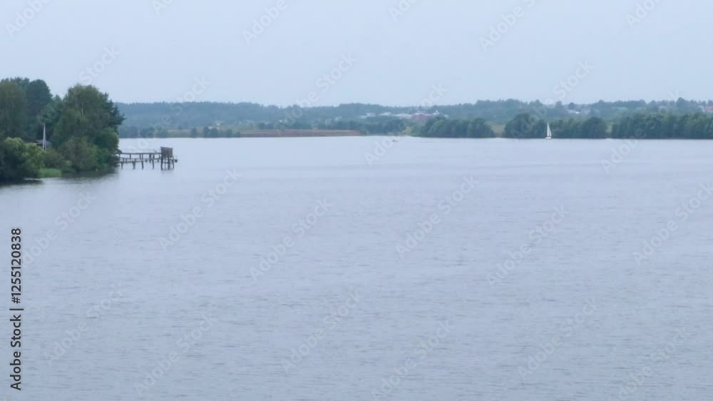 4k video, View of the river early morning in overcast weather, motorboat and sailboat in the distance, opposite bank visible 4k video, View of the river early morning in overcast weather, motorboat and sailboat in the distance, opposite bank visible