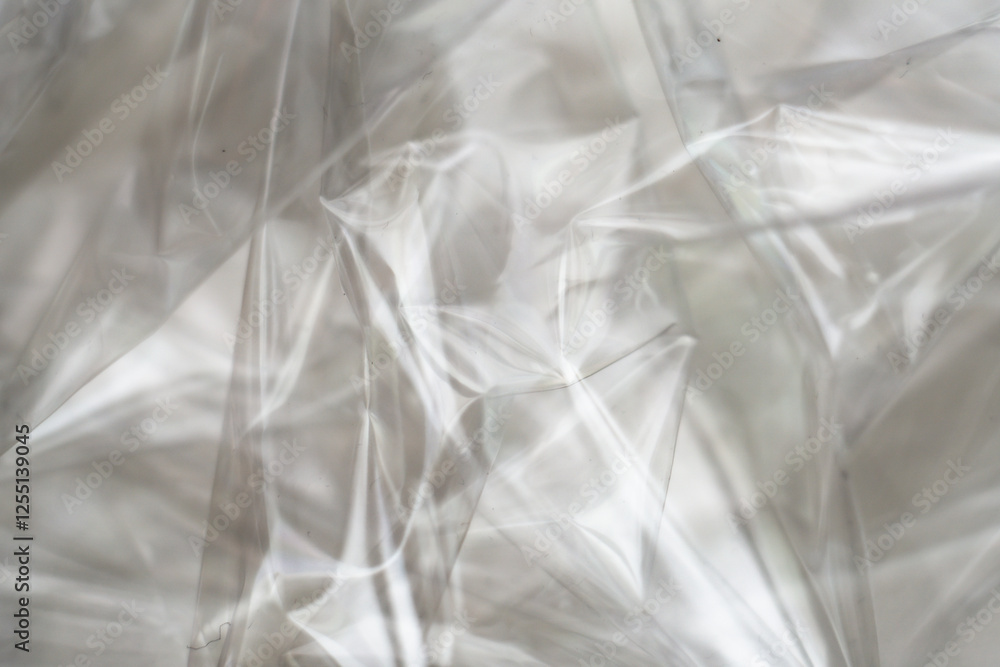 Obraz premium Crumpled clear plastic background, abstract glossy broken surface texture with creases