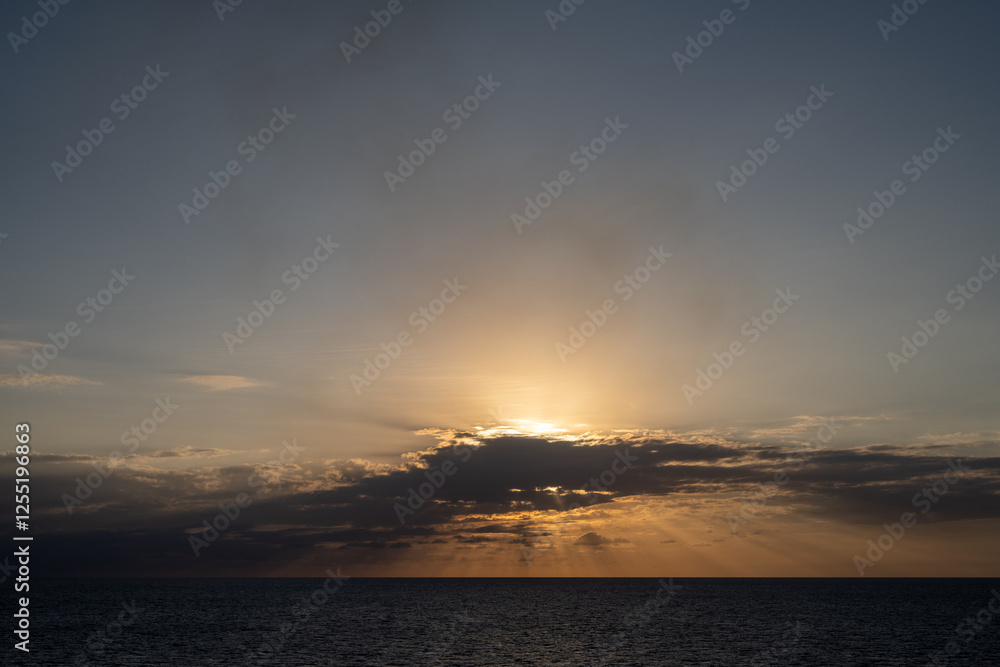 Tropische Meerlandschaft mit einem wunderschönen Sonnenuntergang mit Lichtstrahlen und Wolken Tropische Meerlandschaft mit einem wunderschönen Sonnenuntergang mit Lichtstrahlen und Wolken