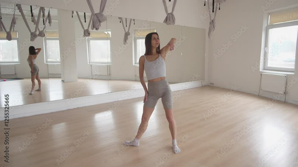 A graceful dancer is standing confidently and gracefully in a bright, modern dance studio filled with energy A graceful dancer is standing confidently and gracefully in a bright, modern dance studio filled with energy