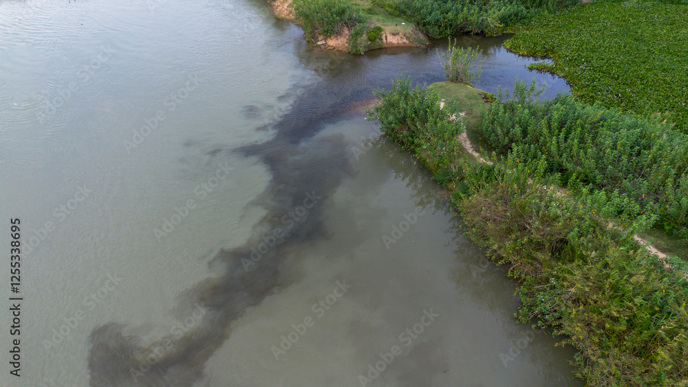 Aerial view of river contaminated with black hazardous liquid Aerial view of river contaminated with black hazardous liquid