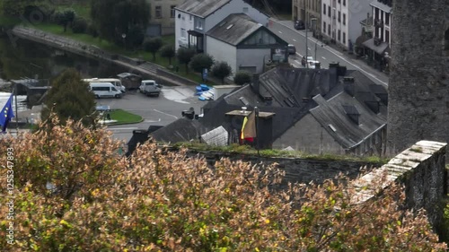 Drone shot revealing Belgian flag flying in the wind on Bouillon Castle