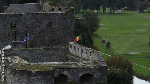 Drone shot of Belgian and EU flags flying in the wind on Bouillon Castle