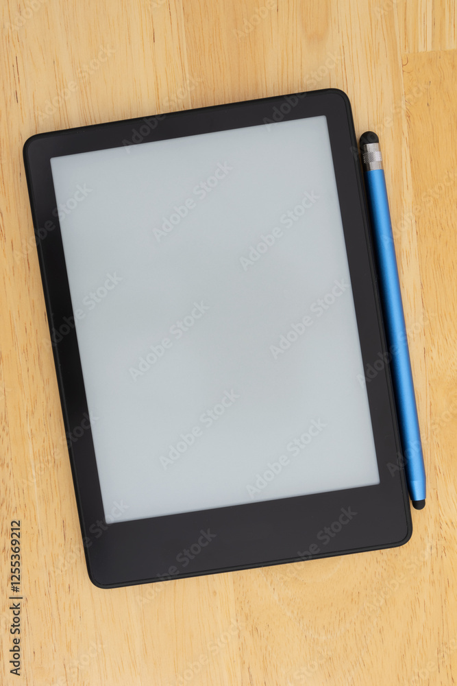 Ereader with a stylus on a wooden desk Ereader with a stylus on a wooden desk