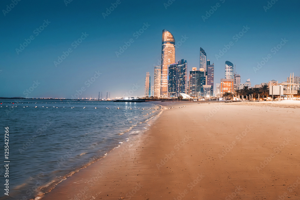 Illuminated skyscrapers of Abu Dhabi reflecting on the wet sand of the beach at dusk, creating a vibrant, tranquil cityscape by the sea Illuminated skyscrapers of Abu Dhabi reflecting on the wet sand of the beach at dusk, creating a vibrant, tranquil cityscape by the sea