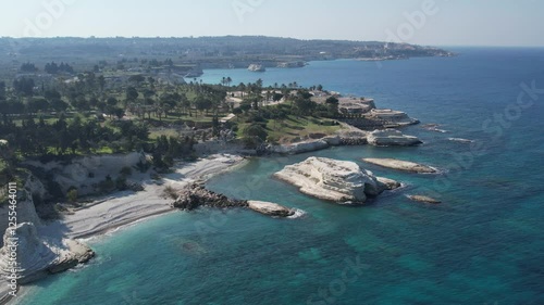 Aerial shot of crashing ocean waves and rocky shores, showcasing the dynamic movement of the water.